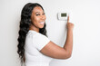 © Louis-Paul Photo - African woman lady adjusting the climate control panel on the wall wall thermostat