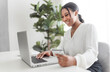 © Louis-Paul Photo - young African American businesswoman working at laptop at home office with credit card
