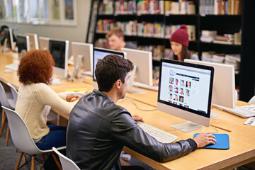 Sticker - Gathering information for his research project. Shot of students working on computers in a university library.