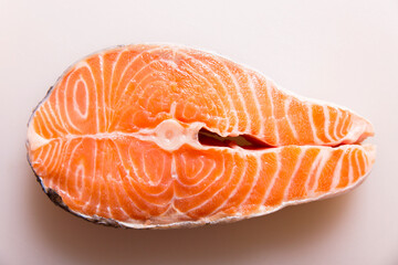 Salmon steak on a white cutting board
