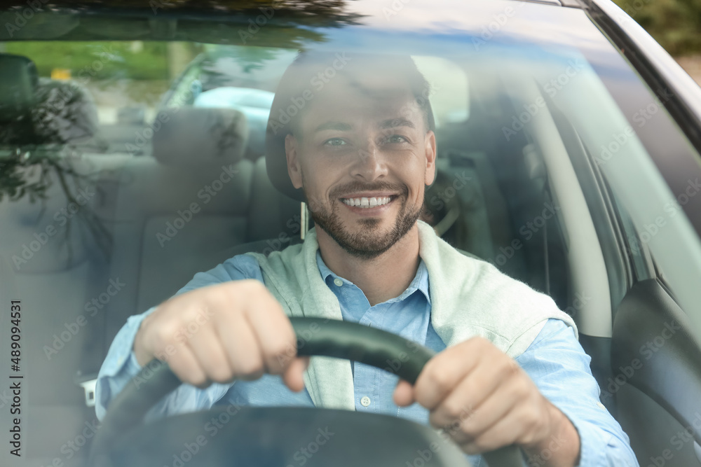 Handsome businessman driving car in city