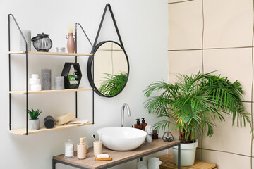 Poster - Shelf unit, table with different bath supplies and modern sink near light wall