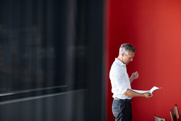 Wall Mural - Making sure he brings his A-game to the meeting. Shot of a handsome businessman going through his paperwork in the office.