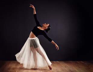 Elegance personified. Young female contemporary dancer using a soft white white skirt for dramatic effect.