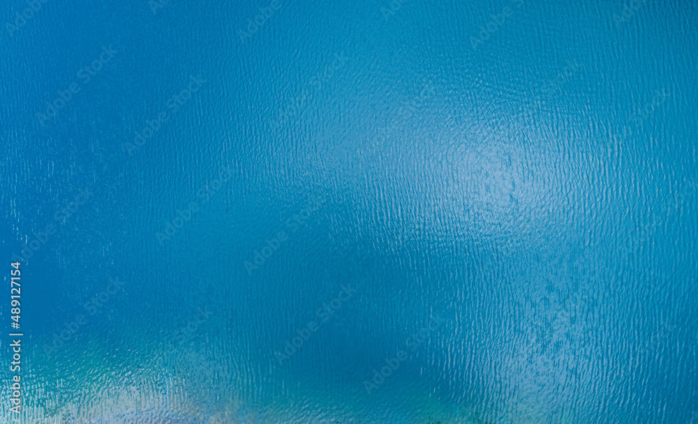 Aerial view of a blue sea surface water texture background and sun ...