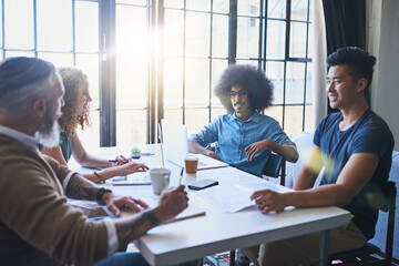 Poster - Exchanging ideas. Shot of a group of cheerful creative businesspeople having a meeting around a table together inside the office during the day.