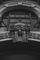 Poster - A grayscale shot of a sculpture on ancient building in old city