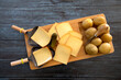 top view of raw raclette cheese on wooden board with potatoes