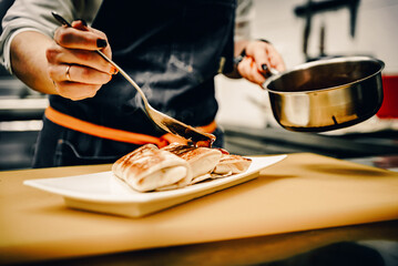 Wall Mural - chef cooking food. Chef's hands cooking pancakes crepe rolls with ground meat on kitchen