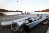 Fototapeta Łazienka - Metal pipes lay on the ground of small cargo port