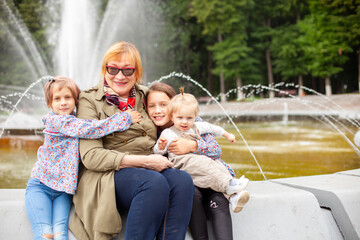 Sticker - Portrait of   elderly woman with grandchildren  on   spring day in   park.