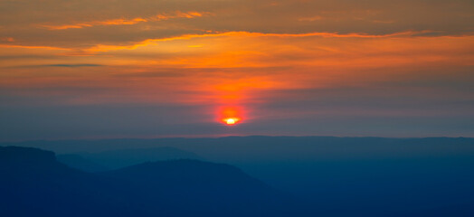 Wall Mural - warm and cool panorama colorful sunset on top of asian mountain.the sun rising from the mountain pea