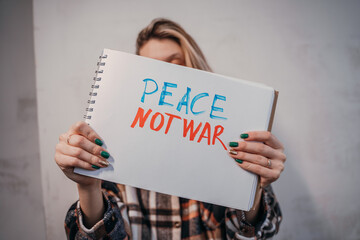 Protesting woman holding a placard with the inscription, Peace no war