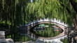 Eine alte kaiserliche Brücke unter Trauerweiden im schönen Naturpark des alten Sommerpalastes in Peking