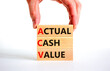 ACV actual cash value symbol. Concept words ACV actual cash value on blocks on a beautiful white table, white background. Businessman hand. Business and ACV actual cash value concept. Copy space.