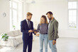© Studio Romantic - Happy couple signs lease or purchase agreement after inspecting house at meeting with realtor. Excited woman puts her signature while standing with her husband in living room of her new home.