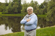 © Studio Romantic - Retired man with gray hair relaxes in nature in the morning. Portrait of a happy senior retired man enjoying retirement walking on a summer day in the park. Senior citizen lifestyle concept.