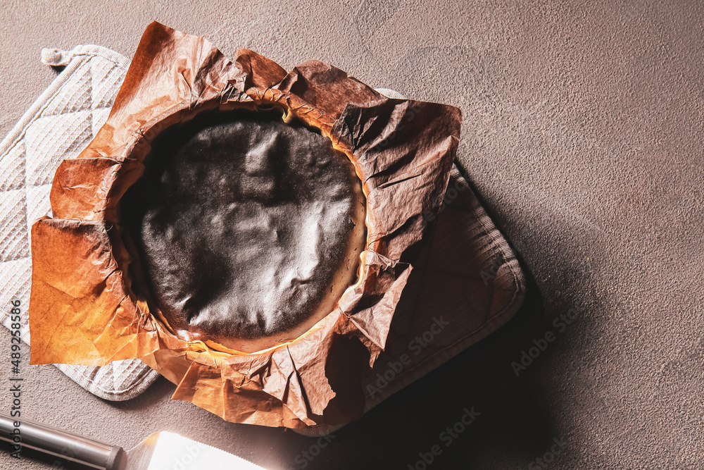 Tasty Basque burnt cheesecake on dark background