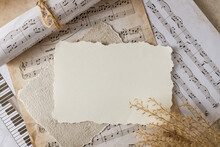 Blank Vintage Paper Card On Aged Music Notes Background. Empty Grunge Postcard With Copy Space.