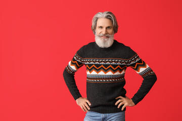 Sticker - Handsome senior man in knitted sweater on red background