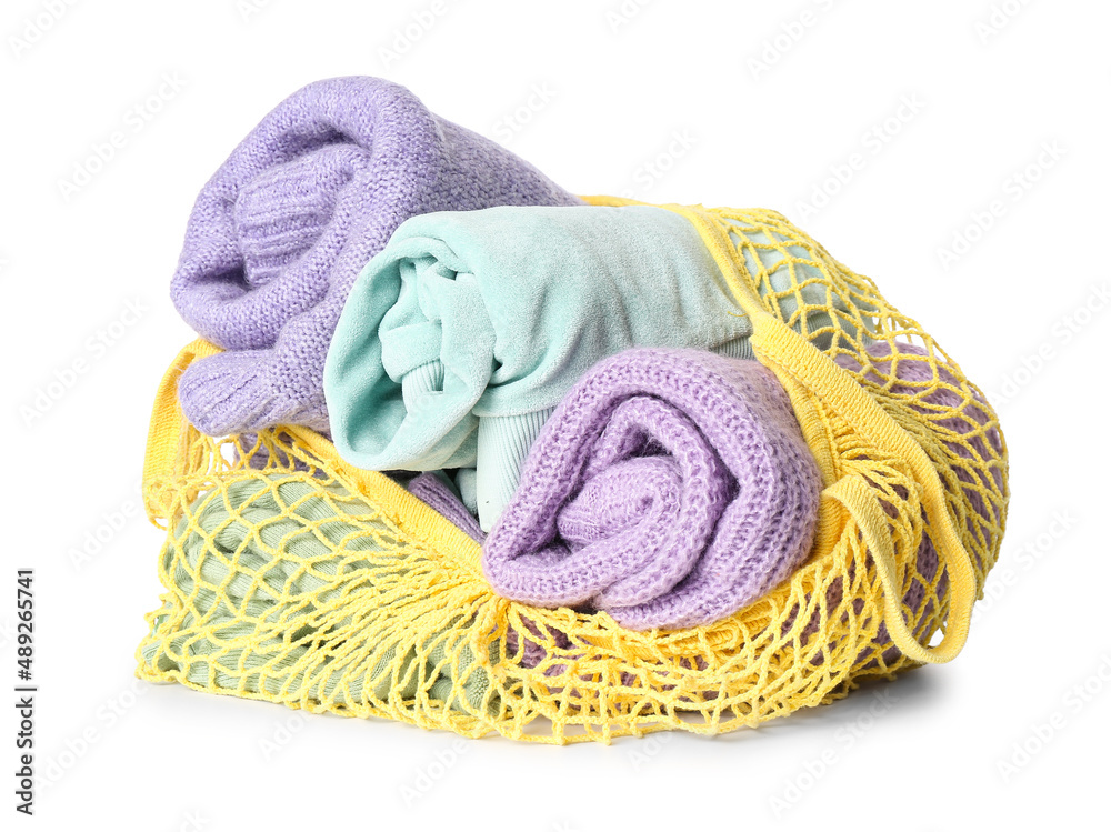 String bag with rolled sweaters on white background