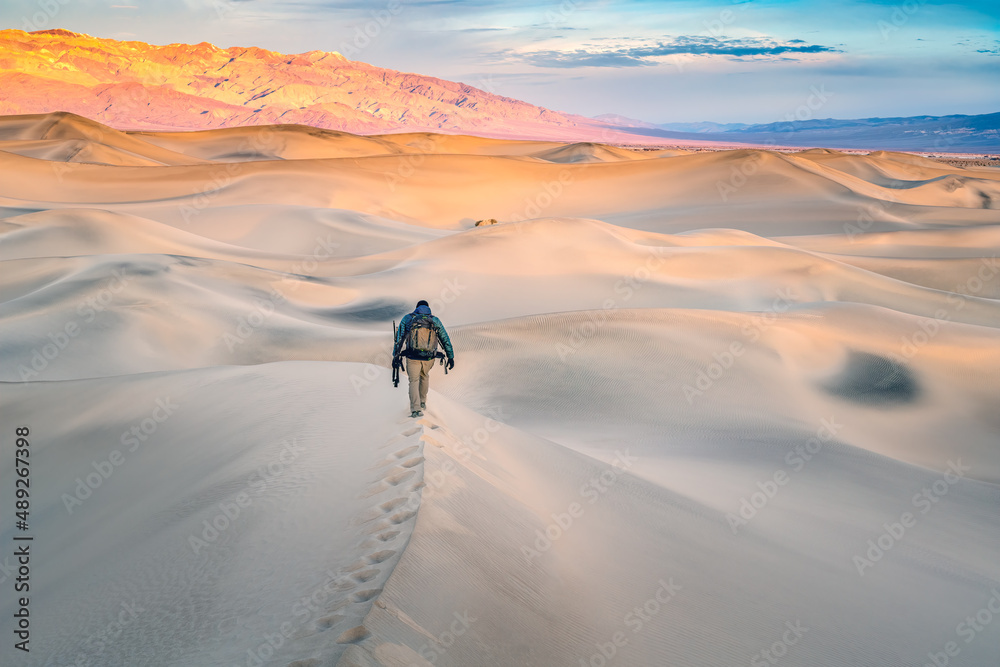 Man walking on top of sand dunes in Death Valley California