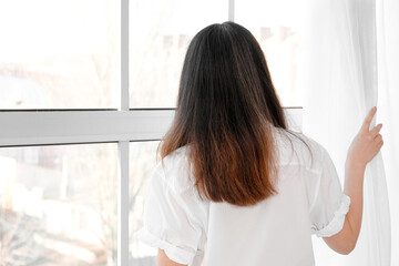 Wall Mural - Pretty young Asian woman near window