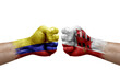 Two hands punch to each others on white background. Country flags painted fists, conflict crisis concept between colombia and gibraltar