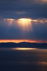 Wall Mural - Angel's ladder is a phenomenon in which when the sun is hidden in clouds, light leaks from the gaps or edges of the clouds, and the pillars of light rays radiate down to the ground. 