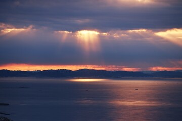 Canvas Print - Angel's ladder is a phenomenon in which when the sun is hidden in clouds, light leaks from the gaps or edges of the clouds, and the pillars of light rays radiate down to the ground. 