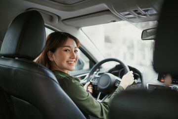 Asian women driving a car and smile happily with glad positive expression during the drive to travel journey