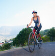 © Tabitha R/peopleimages.com - Enjoying the view from the top. Shot of a lone female rider cycling on a rural road with copy space.