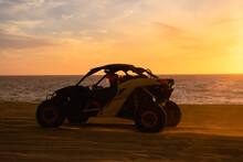 Buggy Running On The Beach At Sunset