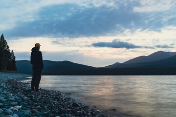 Canvas Print - man on the lake shore at sunset