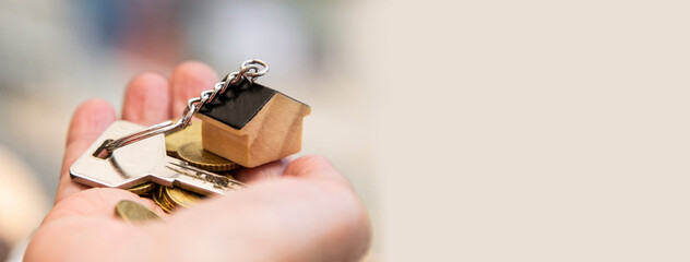 woman holding keys and money with little house keychain. concept of home loan, reverse mortgage, investments and insurance