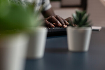 Poster - Close up of african american student hand typing project information on computer keyboard. Freelancer man attending at financial lesson during online webinar working remote from home