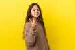 Little caucasian girl isolated on yellow background smiling and showing victory sign