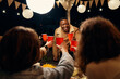 © StratfordProductions - Black male standing, making toast at rooftop party with group of diverse friends at an outdoor party. Red cups, good times.