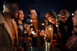 © StratfordProductions - Diverse group of friends laughing at a party on a rooftop terrace. Nightlife in the city, Lighting Sparklers