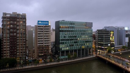 Canvas Print - Fukuoka, Japan. Aerial view of the hotel buildings in the center of Fukuoka, Japan in the cloudy evening. Time-lapse with car traffic with modern buildings, zoom in