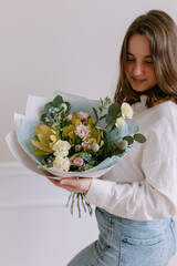 Wall Mural - Young beautiful woman with a bouquet of flowers in her hands Gift for March 8 Women's holiday