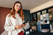 © Jacob Lund - Confident businesswoman holding a smartphone in a boardroom