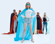 © ASDF - girl leader in superhero Cape standing in front of super team.