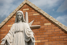 Statue Of Mother Mary In Front Of A Brick Arch