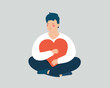 Young man holds, hugs a big heart. Happy adolescent boy sits in lotus pose with closed eyes. Male and cares a red heart with love while sitting. Self acceptance, positive body mental health concept.