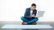 © Arnéll K/peopleimages.com - It began with a plan. Studio shot of a young man sitting on the floor and using a laptop while working on blank paper.