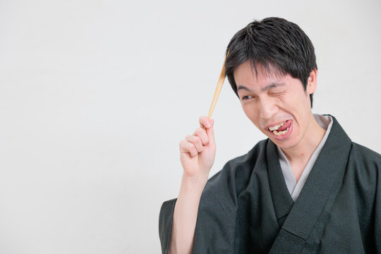 おちゃめ　うっかり　ユニークな表情の着物を着た男性
