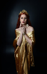  Full length portrait of pretty female model wearing  grecian goddess  toga gown, posing with elegant gestural movements on a studio background.