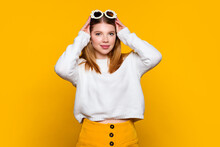 Cute Girl Wears Casual Outfit And Stylish Daisies Sunglasses Looking At Camera And Smile. Young Woman Wait Oncoming Of Spring On Yellow Background. Lifestyle. Trendy Accessory