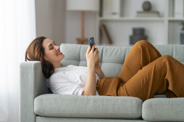 Sticker - woman is using a phone sitting on a sofa